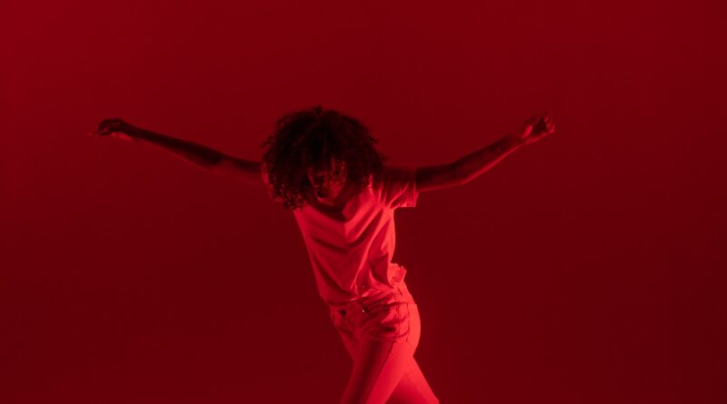 photography of woman dancing near red background