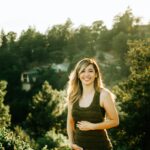 woman standing in front of trees during sunset