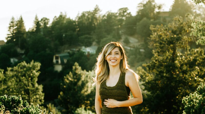 woman standing in front of trees during sunset